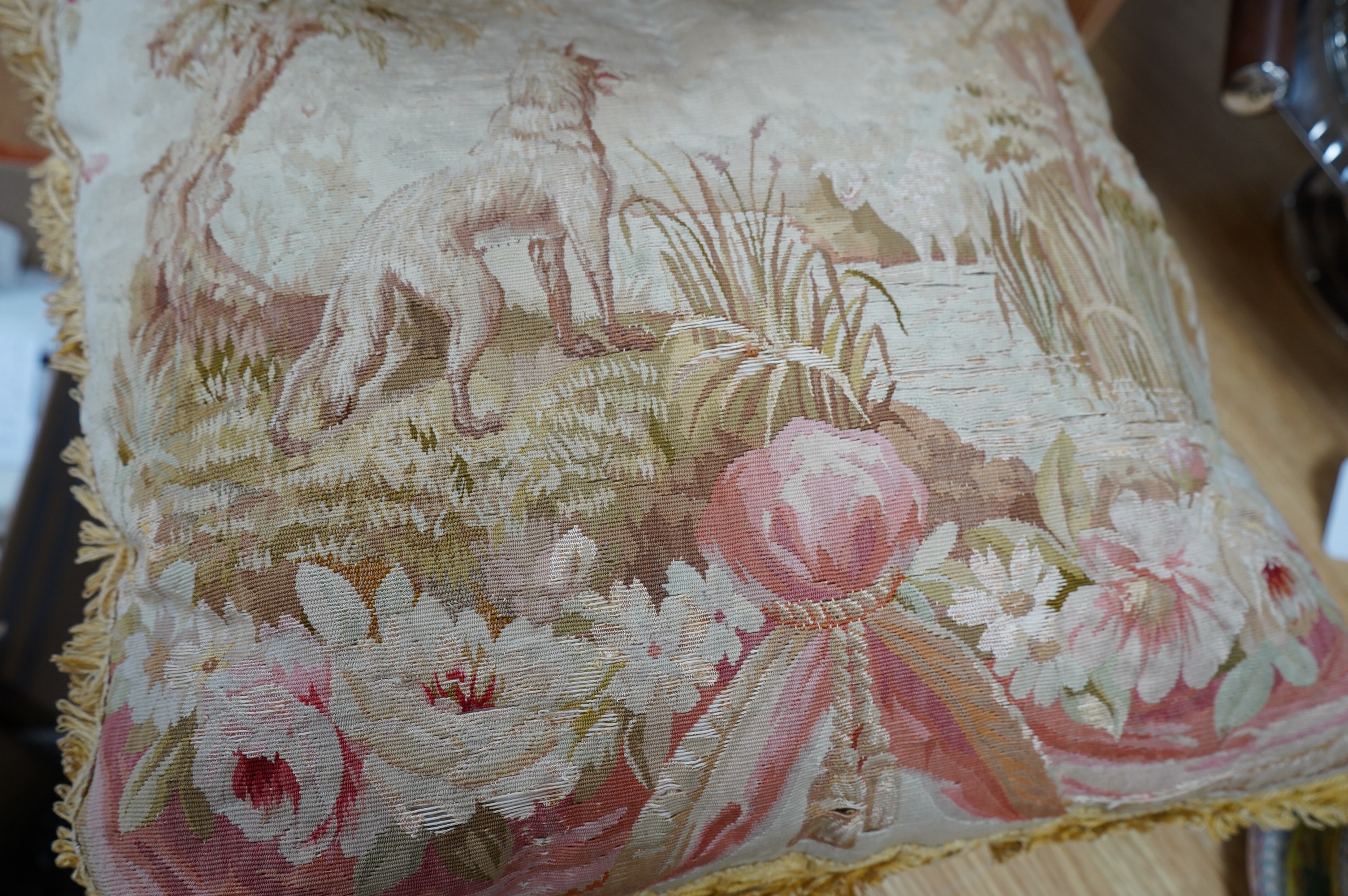 A 19th century Aubusson tapestry made into a cushion, depicting Aesops fable, “The Wolf and the Lamb”. 45cm x 42cm. Condition - the tapestry has worn from use, needs stitching in places, colours good, edging and backing